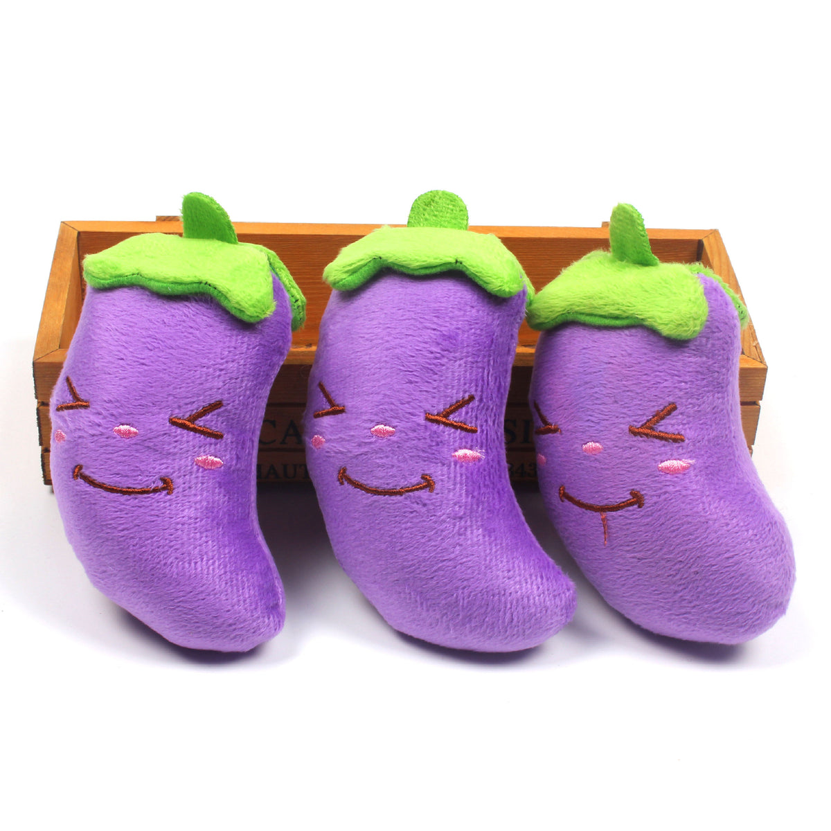 Three purple eggplant plush toys in a row