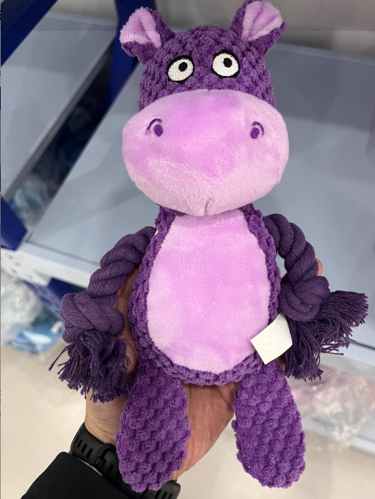 Purple hippo plush dog toy held up, photo